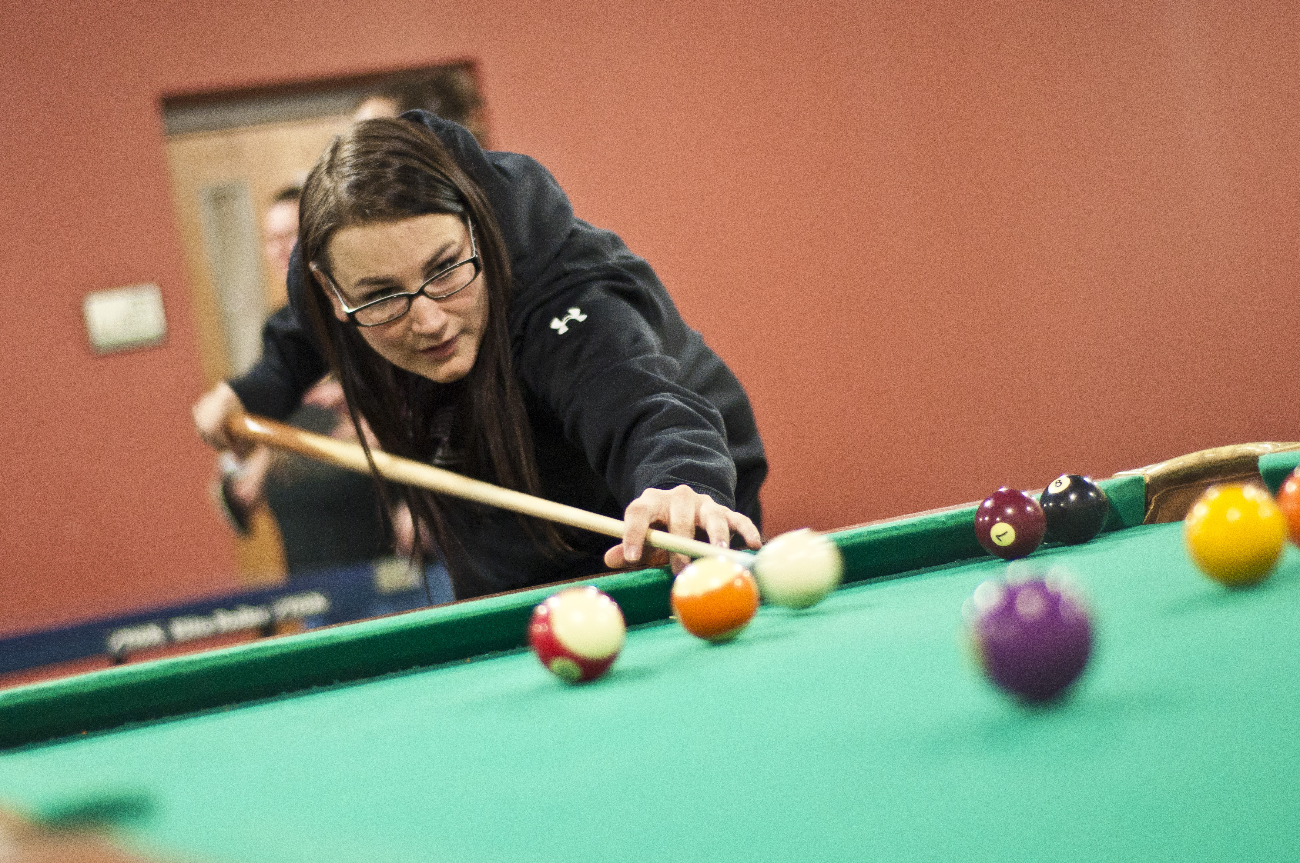 A BHSU student playing pool in the Club Buzz Game Room.